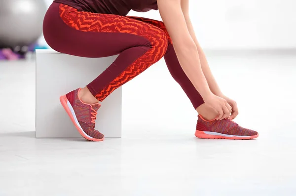 Joven mujer deportiva atando cordones en el gimnasio — Foto de Stock