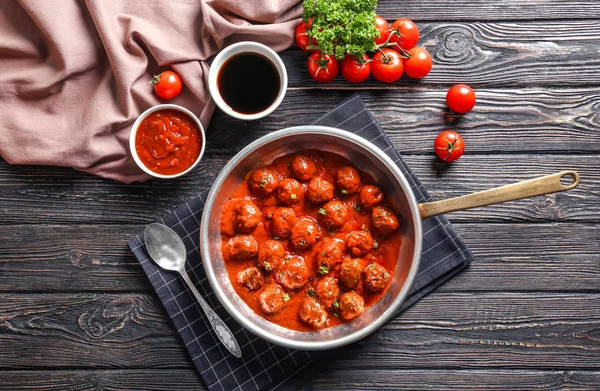 Saucepan with delicious meatballs in tomato sauce on table — Stock Photo, Image