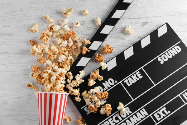 Caramel popcorn and movie clapper — Stock Photo, Image