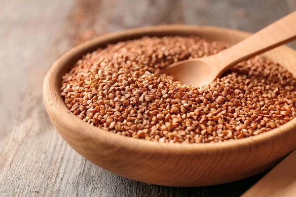 Plate with raw buckwheat and spoon — Stock Photo, Image