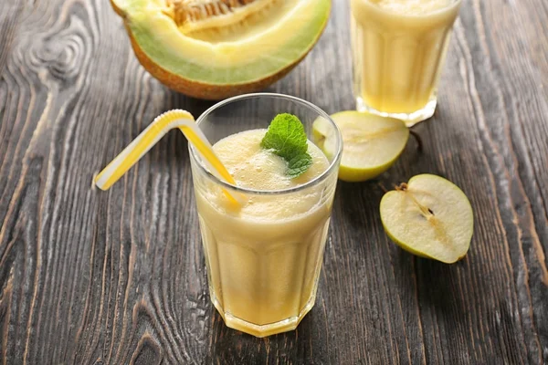 Glass with melon smoothie on table — Stock Photo, Image