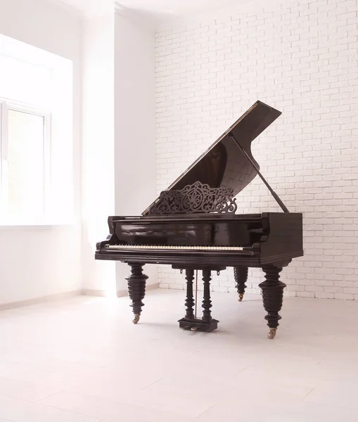 Gran piano con tapa elevada cerca de la pared de ladrillo — Foto de Stock