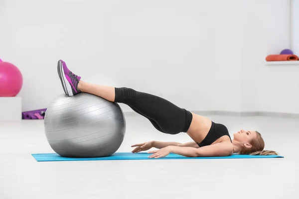 Mulher bonita com treinamento de bola de fitness no ginásio — Fotografia de Stock