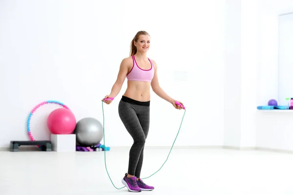 Mujer joven con saltar la cuerda en el gimnasio —  Fotos de Stock