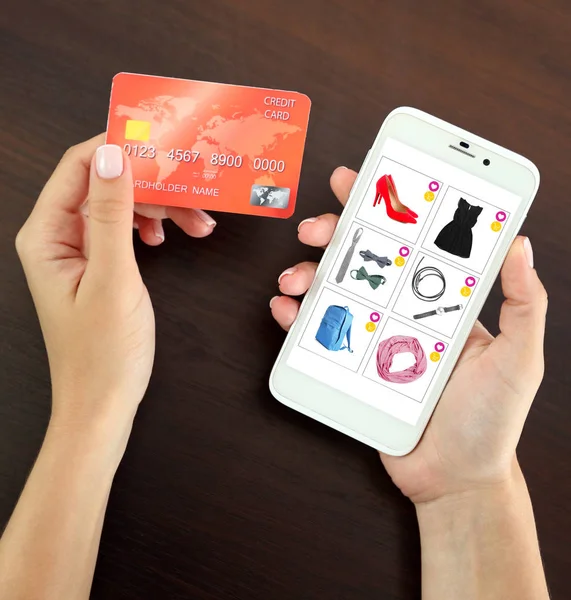 Mulher usando telefone e cartão de crédito para internet compras on-line na mesa — Fotografia de Stock