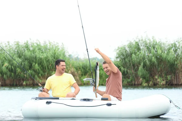两名男子从充气船在河上钓鱼 — 图库照片