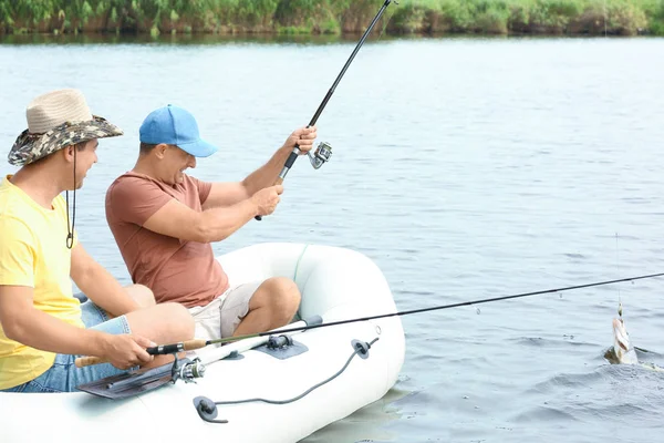 Deux hommes pêchant du bateau gonflable sur la rivière — Photo