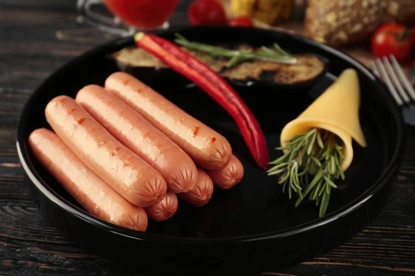 Assiette avec de délicieuses saucisses grillées — Photo