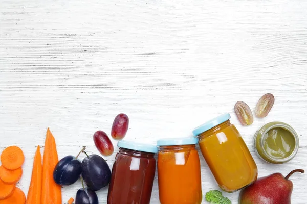 Pots avec différents aliments pour bébés et ingrédients sur la table — Photo