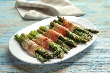 Plaka pastırma ile kuşkonmaz masada sarılmış.