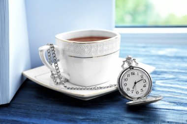Kahve ahşap pencere eşiğinde cep saati Kupası yakınındaki. Sabah rutin kavramı