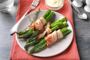 Plaka pastırma ile kuşkonmaz masada sarılmış.