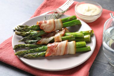 Plaka pastırma ile kuşkonmaz masada sarılmış.