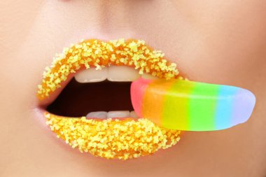 Yaratıcı makyajı olan genç ve güzel bir kadın ağzına reçel koyuyor.