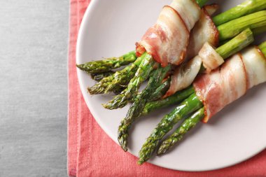 Plaka pastırma ile kuşkonmaz masada sarılmış.