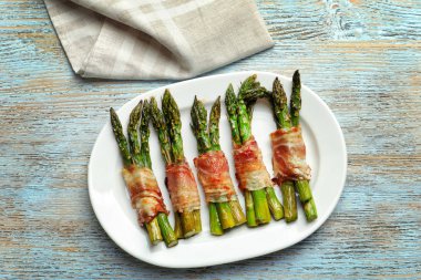 Plaka pastırma ile kuşkonmaz masada sarılmış.