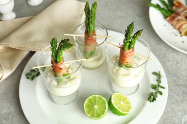 Gözlük pastırma ile kuşkonmaz ve sos masanın üzerine sarılmış