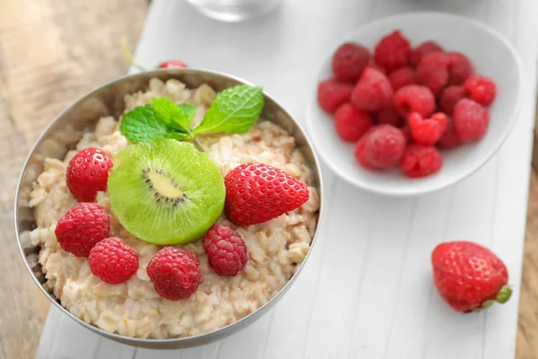 Tasty oatmeal with fruits in bowl, close up — Stock Photo, Image