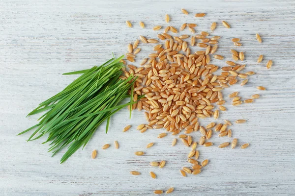 Pile of seeds and wheat grass on wooden table — 图库照片