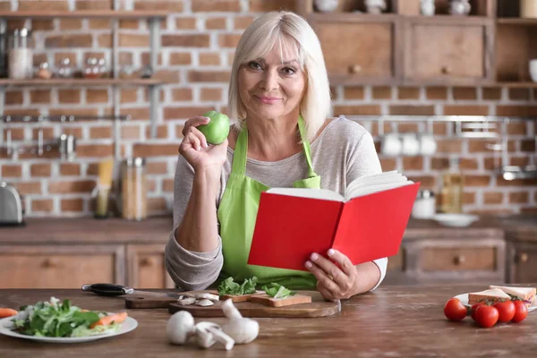 Mature woman cooking in kitchen — Stock Photo, Image