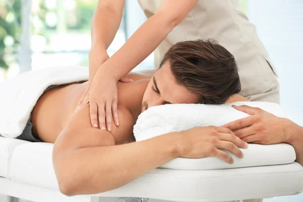 Jongeman met massage in spa salon — Stockfoto