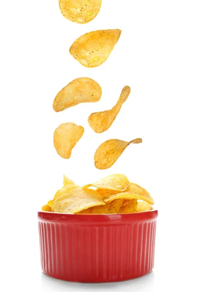 Tasty potato chips falling into bowl — Stock Photo, Image