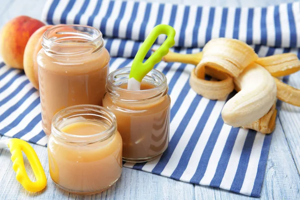 Jars with different baby food on wooden table — Stock Photo, Image