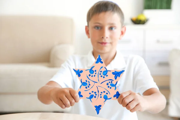 Niño sosteniendo estrella ornamentada en casa — Foto de Stock