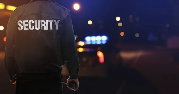 Security guard near car outdoors at night — Stock Photo, Image