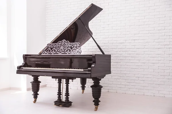 Grand piano with raised lid near brick wall — Stock Photo, Image