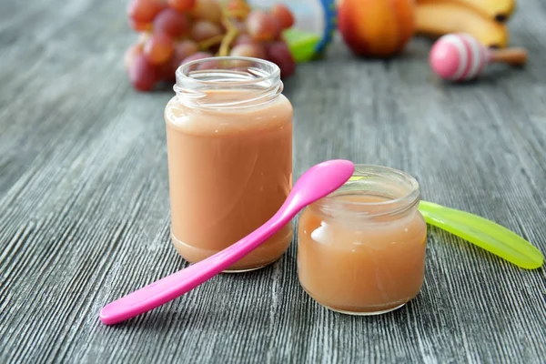 Potten met babyvoeding op houten tafel — Stockfoto