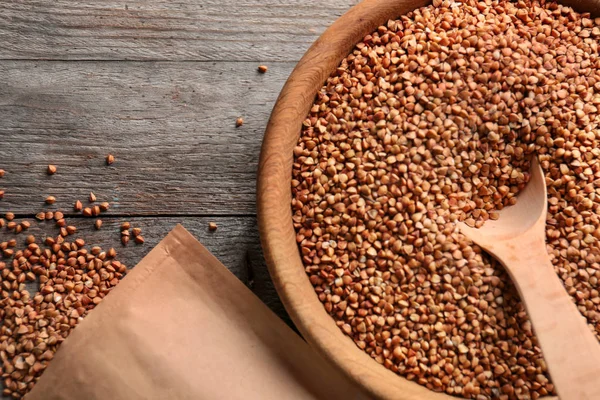 Plate with raw buckwheat and spoon — Stock Photo, Image