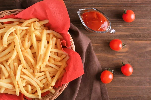 Korg med smaskiga pommes frites på bord — Stockfoto