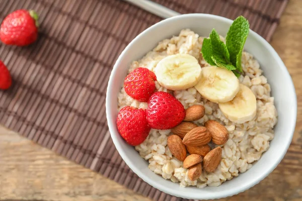 Farina d'avena saporita con frutta in ciotola sul tavolo — Foto Stock