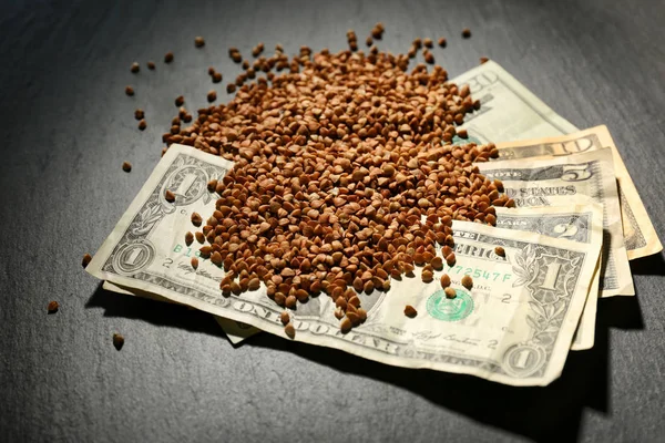 Raw buckwheat and money on table — Stock Photo, Image
