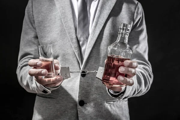 Mann mit Handschellen, Glas und Flasche — Stockfoto
