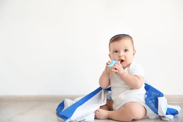 Lindo bebé en kippah con gran bandera de Israel y dreidel sentado en el suelo en casa — Foto de Stock