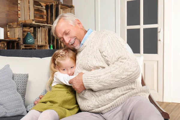 Homem idoso com neta em casa — Fotografia de Stock