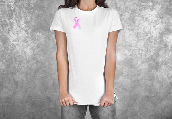 Молодая женщина с розовой лентой на цветном фоне. Концепция рака молочной железы
