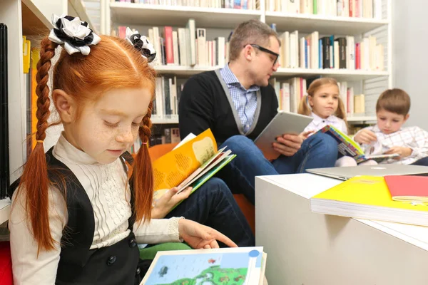 Enseignant et écoliers à la bibliothèque — Photo