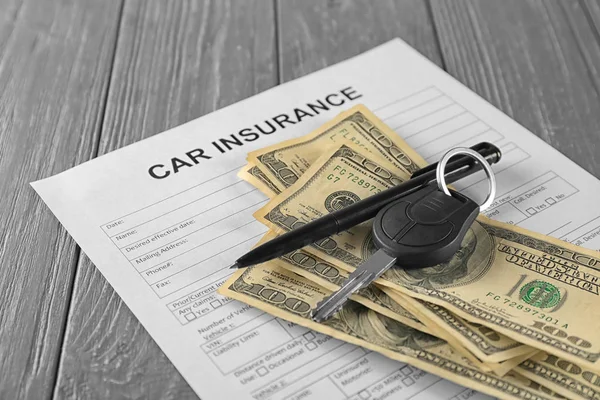 Formulario de seguro de coche, llave y dinero en la mesa — Foto de Stock