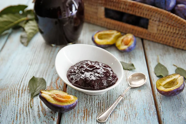 Small bowl with tasty plum jam on wooden background — Stock Photo, Image