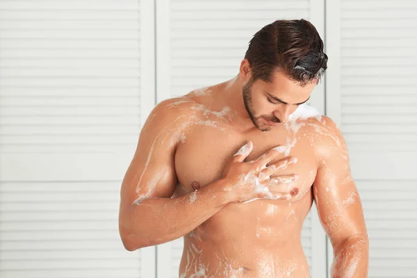 Schöner junger Mann wäscht sich in der Dusche — Stockfoto