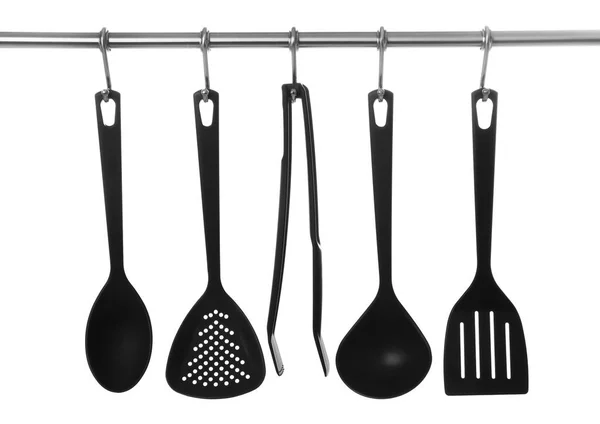 Set of cooking utensils hanging on rack — Stock Photo, Image