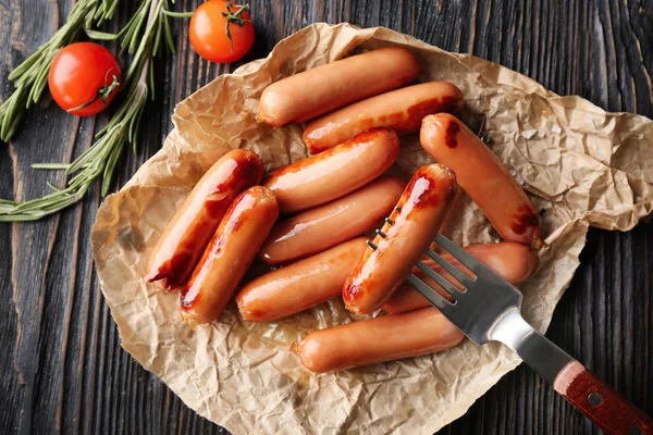 Delicious grilled sausages on parchment — Stock Photo, Image