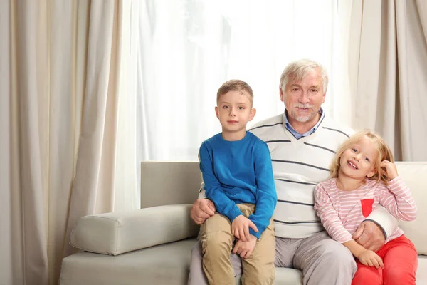 Anciano con nietos en casa — Foto de Stock