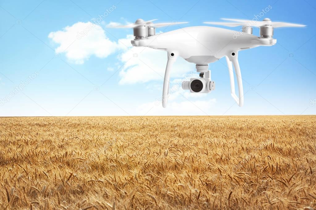 Quadcopter with camera flying over field