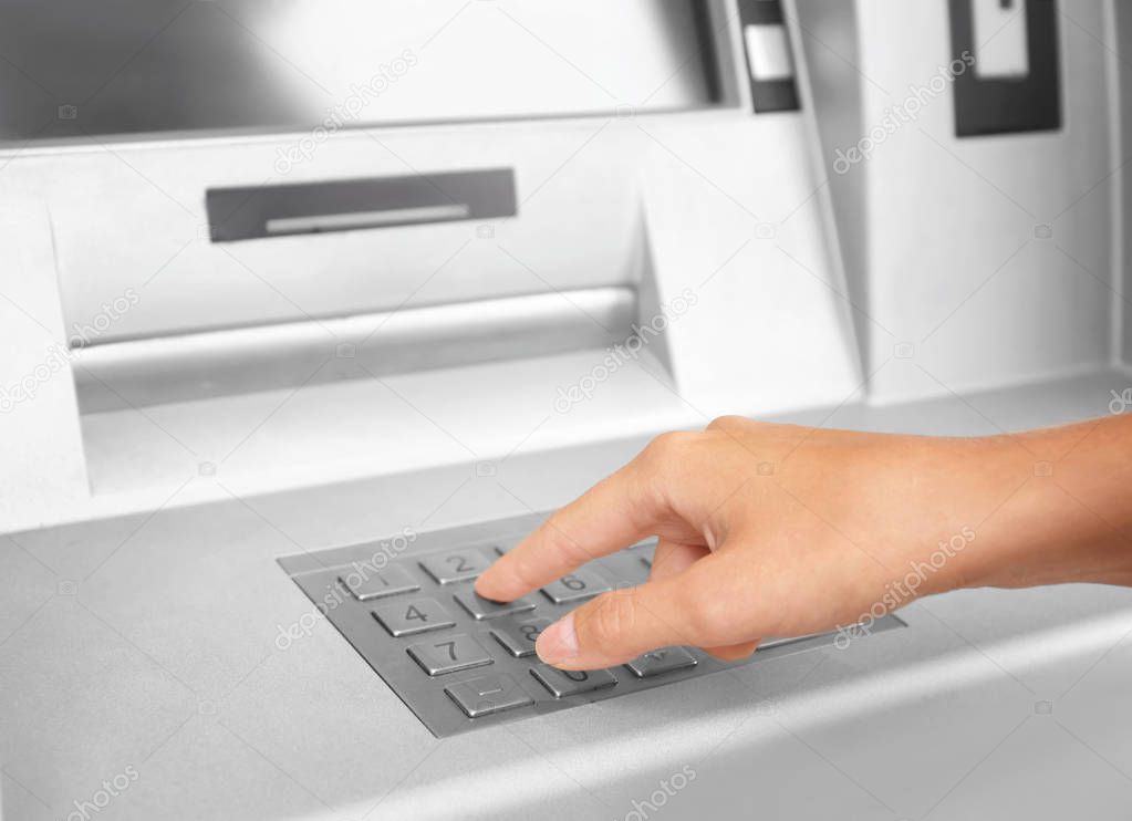 Woman entering cash machine pin code, closeup