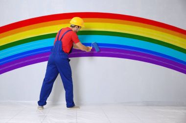 Genç bir işçi boya gökkuşağı duvar odadaki