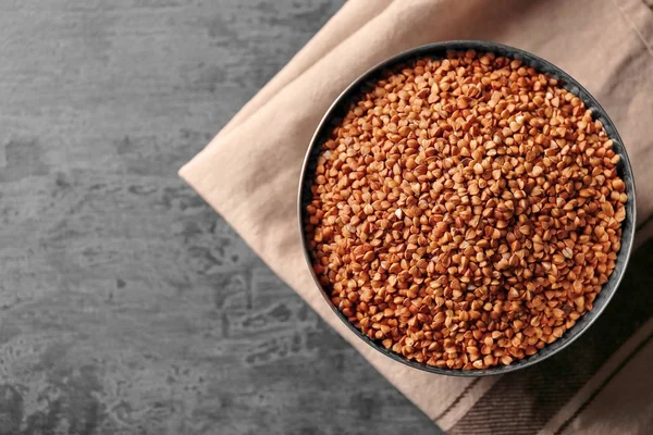 Raw buckwheat in metal bowl — Stock Photo, Image